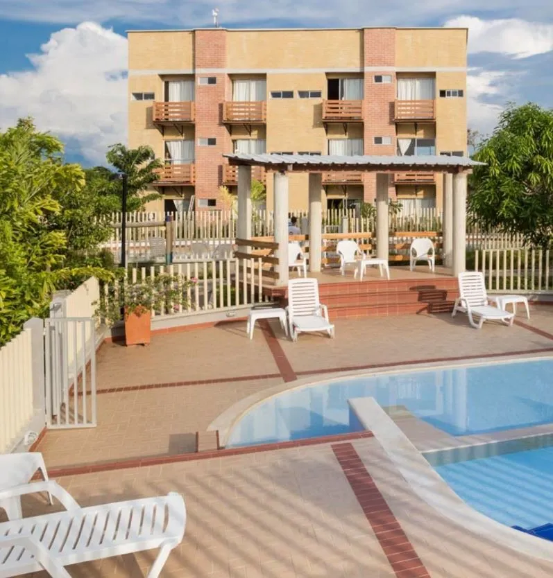 Edificio de apartamentos y terraza junto a la piscina en una fotografía de referencia de AVT