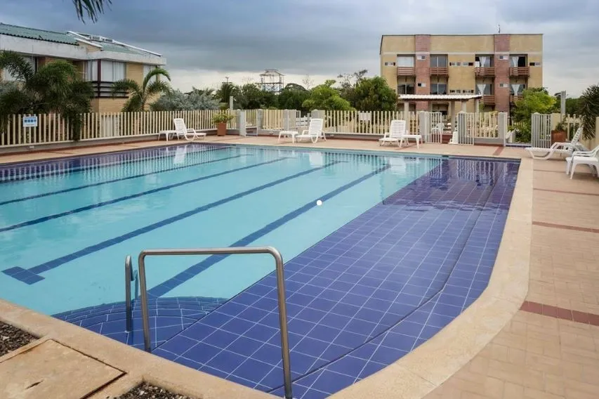 Piscina con escalera y terraza junto a edificios de apartamentos; referencia aportada por AVT