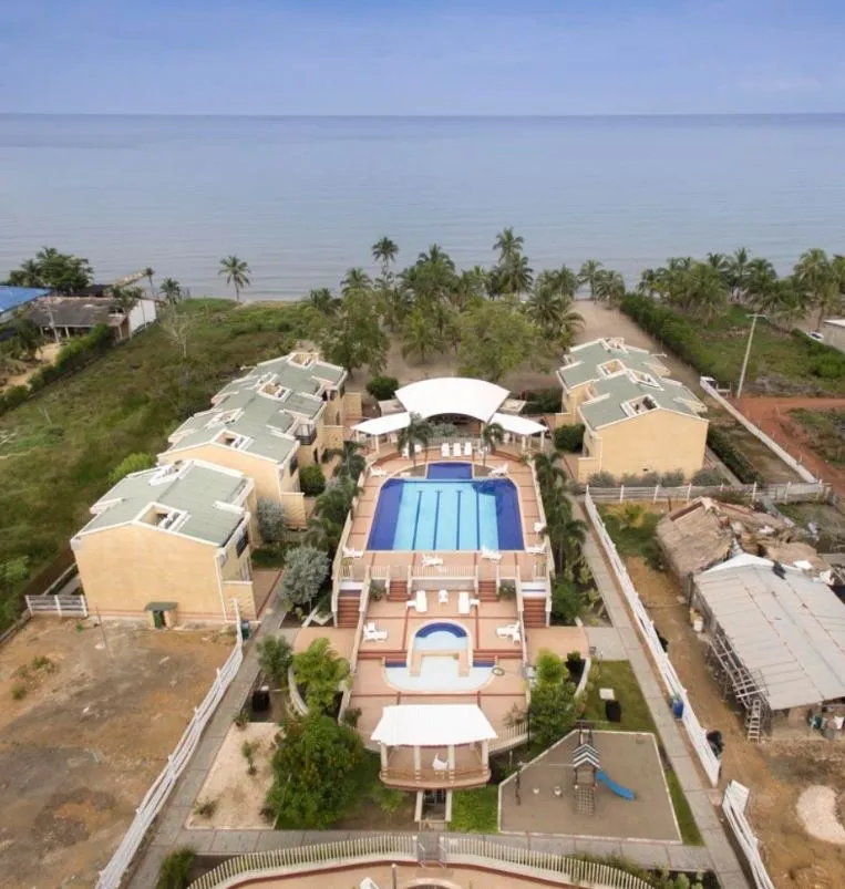 Vista aérea del conjunto con edificios, piscinas y el mar al fondo; referencia aportada por AVT